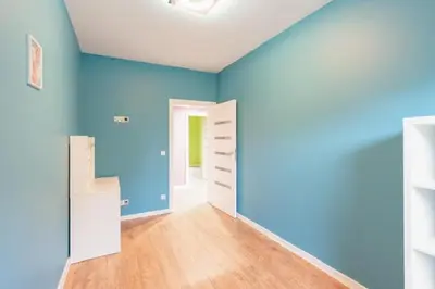 an empty room with blue walls and wooden floors at Niepołomice, kwatery, nocleg, pokoje,kwatery pracownicze in Niepołomice
