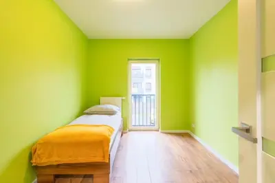 a green room with a bed and a window at Niepołomice, kwatery, nocleg, pokoje,kwatery pracownicze in Niepołomice