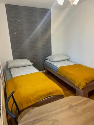 a room with two beds with yellow sheets and a window at Bochnia,kwatery pracownicze,duży dom, noclegi in Bochnia