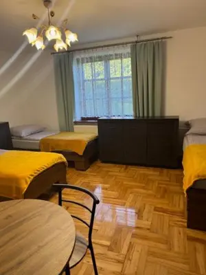 a room with two beds and a table and chairs at Bochnia,kwatery pracownicze,duży dom, noclegi in Bochnia