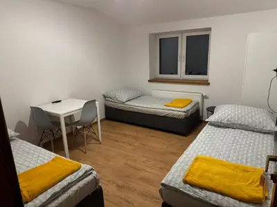 a room with two beds and a table and a desk at Łysokanie, Niepołomice , noclegi, kwatery dla firm, pokoje in Łysokanie