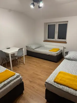 a room with three beds and a desk and a table at Łysokanie, Niepołomice , noclegi, kwatery dla firm, pokoje in Łysokanie