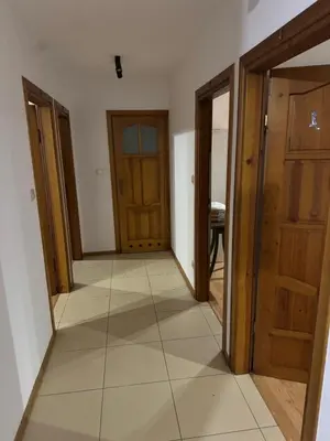 a hallway with wooden doors and a tile floor at Łysokanie, Niepołomice , noclegi, kwatery dla firm, pokoje in Łysokanie