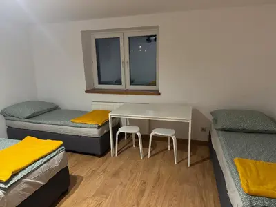 a room with two beds and a table with two stools at Łysokanie, Niepołomice , noclegi, kwatery dla firm, pokoje in Łysokanie