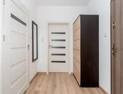 a living room with a couch and a kitchen at Zabłocie Deluxe Apartment by BookingHost in Kraków
