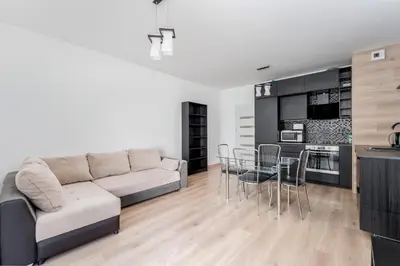 a living room with a couch and a table at Zabłocie Deluxe Apartment by BookingHost in Kraków