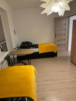 a room with a bed and a table and yellow towels at Podłęże, Niepołomice, noclegi, kwatery pracownicze dla firm