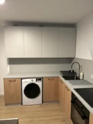 a kitchen with white cabinets and a white dishwasher at Podłęże, Niepołomice, noclegi, kwatery pracownicze dla firm