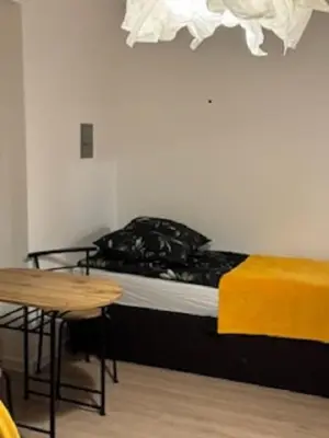 a room with a bed and a table and a table and a table at Podłęże, Niepołomice, noclegi, kwatery pracownicze dla firm