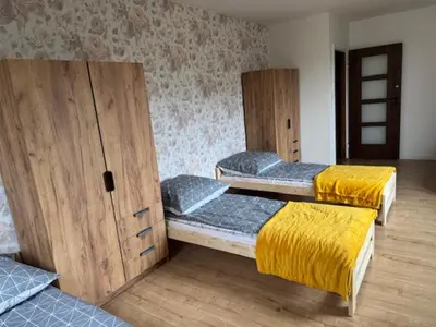 a room with three bunk beds with yellow blankets at Niepołomice,noclegi, pokoje, cały dom, kwatery pracownicze in Niepołomice