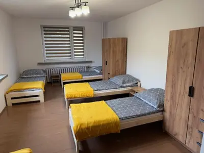 a room with four bunk beds with yellow sheets at Niepołomice,noclegi, pokoje, cały dom, kwatery pracownicze in Niepołomice