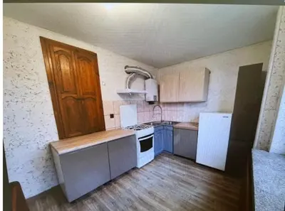 a small kitchen with white appliances and wooden floors at Niepołomice,noclegi, pokoje, cały dom, kwatery pracownicze in Niepołomice