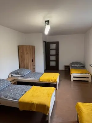 a room with three beds with yellow sheets on them at Niepołomice,noclegi, pokoje, cały dom, kwatery pracownicze in Niepołomice