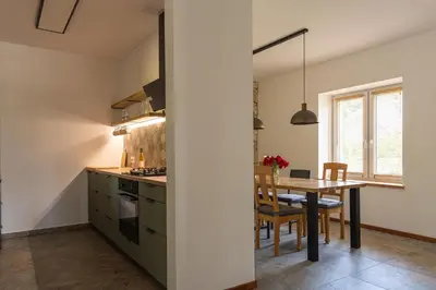 a living room with blue chairs and a wood stove at Dom nad Potokiem in Korzkiew