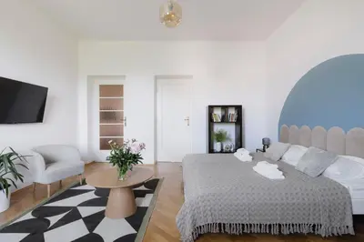 a white room with a bed and a couch and a table at Spacious City Centre Apartment - Słowackiego in Kraków
