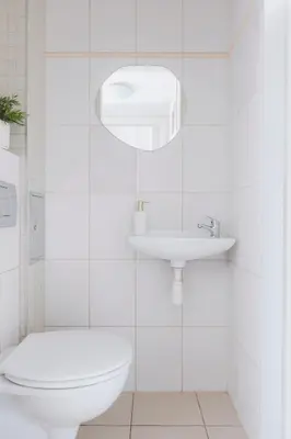 a white bathroom with a toilet and a sink at Spacious City Centre Apartment - Słowackiego in Kraków