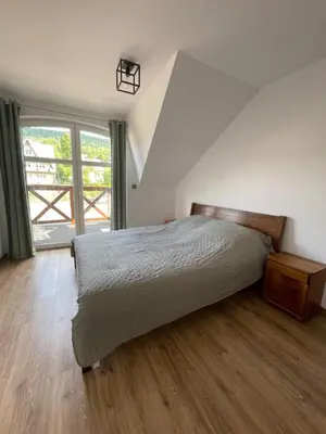 a bedroom with a bed and a large window at Apartament Zawoja in Zawoja
