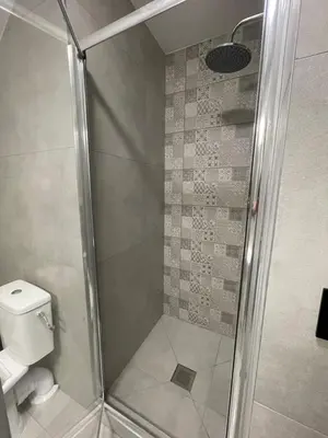 a shower with a glass door next to a toilet at Apartament Zawoja in Zawoja