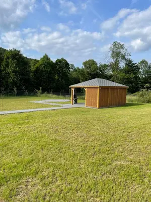 a shed in a field with a grass field at Apartament Zawoja in Zawoja