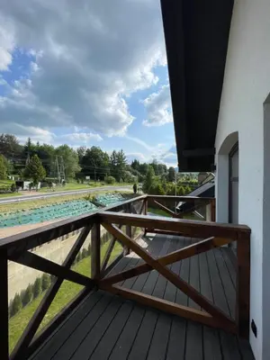 a wooden balcony with a view of a river at Apartament Zawoja in Zawoja