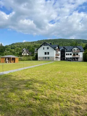 a large field with houses in the background at Apartament Zawoja in Zawoja