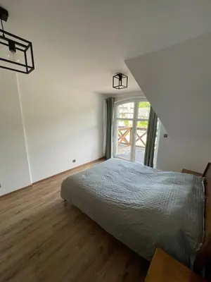 a bedroom with a bed and a large window at Apartament Zawoja in Zawoja