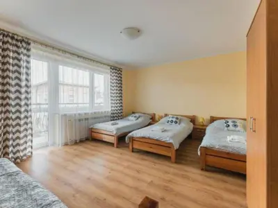 a room with three beds and a large window at Nocleg Wadowice 2 in Wadowice