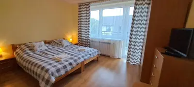 a bedroom with a bed and a tv and a window at Nocleg Wadowice 2 in Wadowice