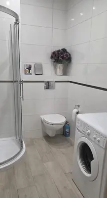 a bathroom with a washing machine and a toilet at Lightrooms Apartments in Kraków