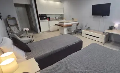 a living room with a bed and a kitchen at Lightrooms Apartments in Kraków