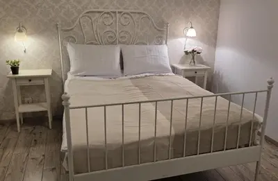a bedroom with a white bed with two night stands at Lightrooms Apartments in Kraków