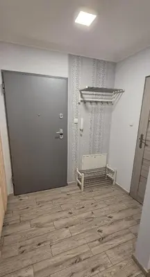 a room with a door and a wooden floor at Lightrooms Apartments in Kraków