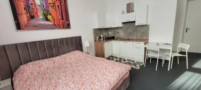 a bedroom with a bed and a kitchen with a table at Asnyk Prestige Apartments in Kraków