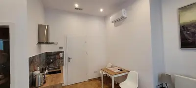a white room with a table and a small table and a table and chairs at Asnyk Prestige Apartments in Kraków