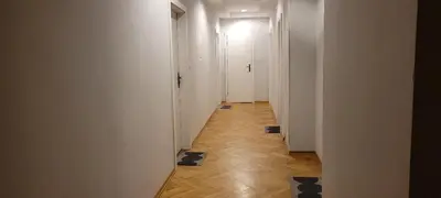 a hallway with white walls and wooden floors and a white hallway at Asnyk Prestige Apartments in Kraków