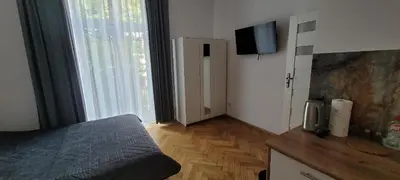a bedroom with a bed and a television on a wall at Asnyk Prestige Apartments in Kraków