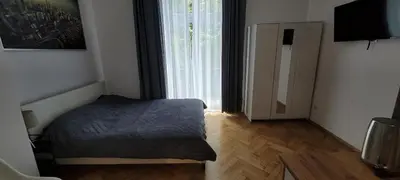 a bedroom with a bed and a large window at Asnyk Prestige Apartments in Kraków