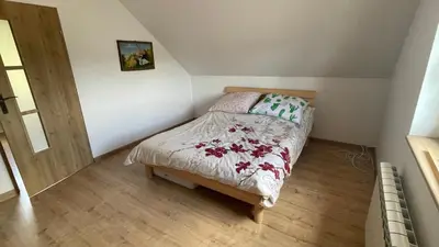 a small bedroom with a bed in a attic at Domek w Limanowej in Limanowa