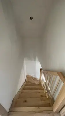 a staircase in a room with a white wall at Domek w Limanowej in Limanowa