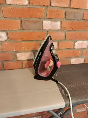 a iron sitting on a table next to a brick wall at EliBlue -Twój apartament in Trzebieńczyce