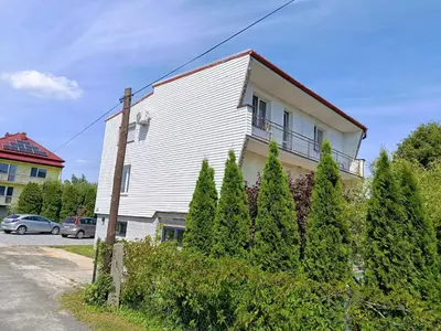 a white house with a balcony on the side of it at EliBlue -Twój apartament in Trzebieńczyce
