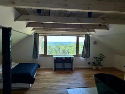 a bedroom with a large window in a attic at Rogaty Dworek in Kornatka