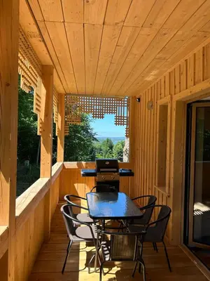 a wooden porch with a table and chairs on it at Rogaty Dworek in Kornatka