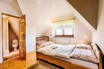 a bedroom with a wooden bed and a painting on the wall at Agrozacisze in Zubrzyca Górna