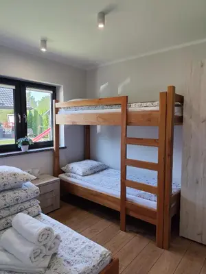a bedroom with two bunk beds and a ladder at Domki pod skarpą Zator 27 in Zator