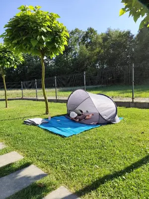 a person laying in a tent on the grass at Domki pod skarpą Zator 27 in Zator