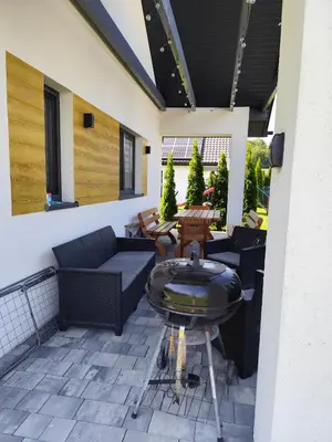 a patio with couches and a table and a grill at Domki pod skarpą Zator 27 in Zator