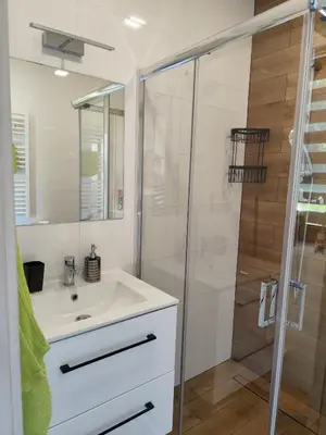 a bathroom with a white sink and a shower at Domki pod skarpą Zator 27 in Zator