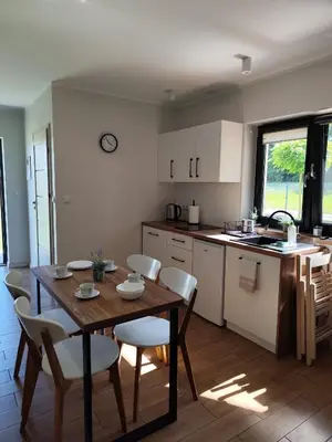 a kitchen and dining room with a table and chairs at Domki pod skarpą Zator 27 in Zator