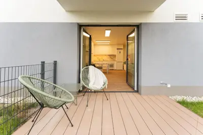 two chairs on a deck with a house at Bohomolca Chic Studio with Garden by BookingHost in Kraków